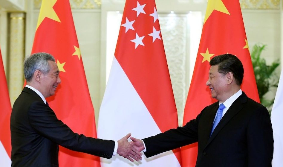 Singapore’s Prime Minister Lee Hsien Loong (L) shakes hands with China’s President Xi Jinping