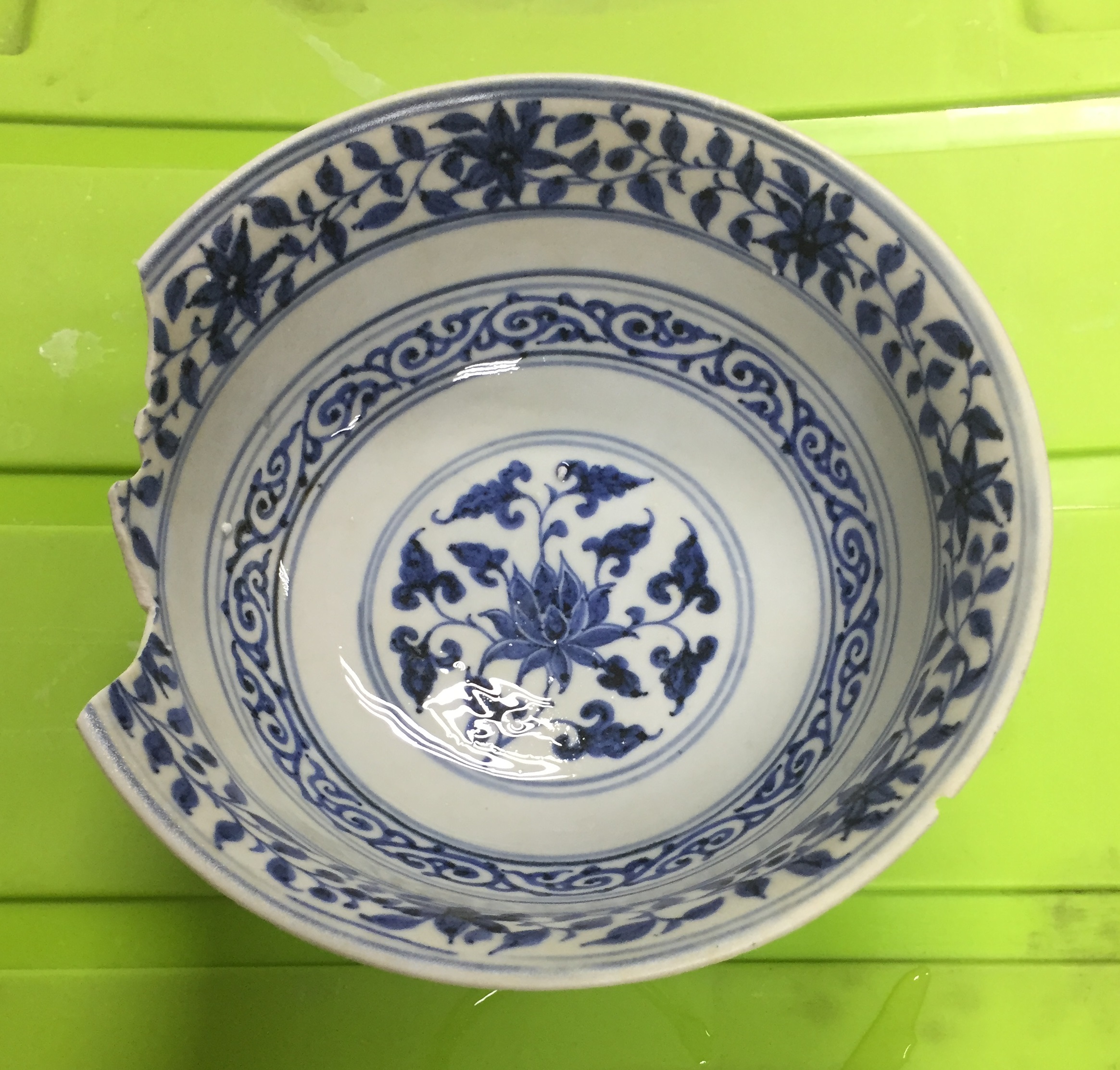 Nearly intact blue-and-white bowl with alternating lotus and scroll decoration from SW1